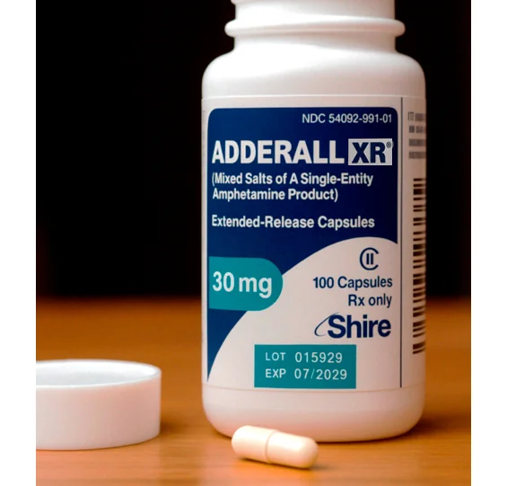 Флакон с перпаратом аддерал и капсулами на столе